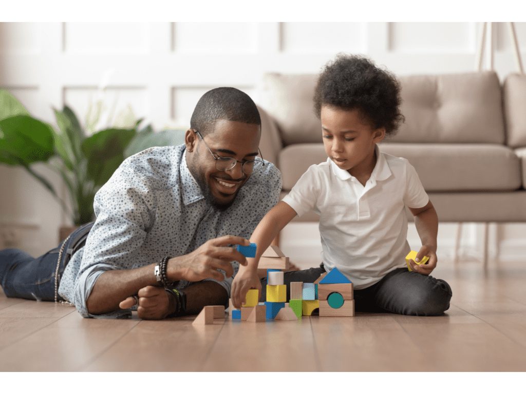Child stacking blocks to develop fine motor skills for kindergarten readiness.